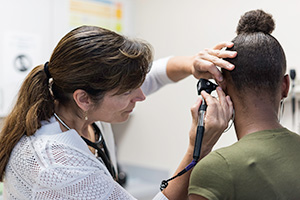 Nurse examining student at East High Clinic