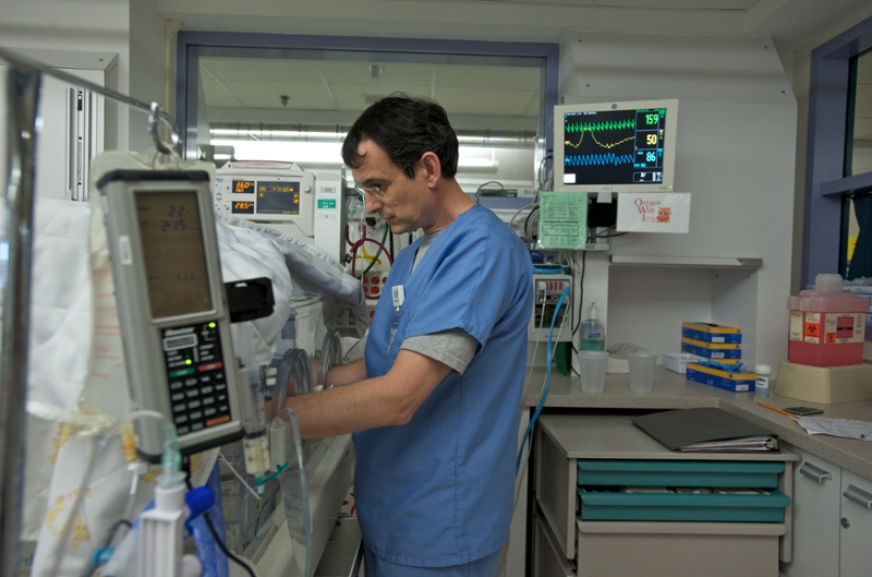 Patrick Hopkins, in a blue nursing uniform, working in Strong's neonatal intensive care unit.