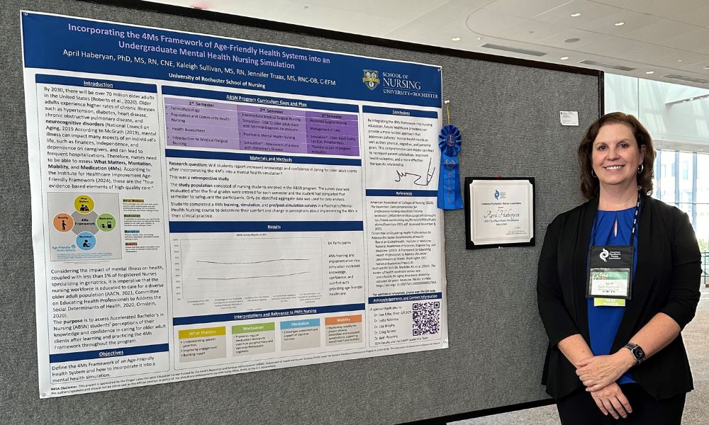 Haberyan stands next to a research poster with a blue 1st place ribbon