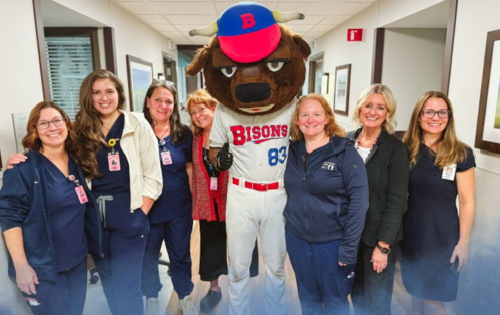 Meghan and co-workers pose in a photo with the Buffalo Bisons baseball mascot.